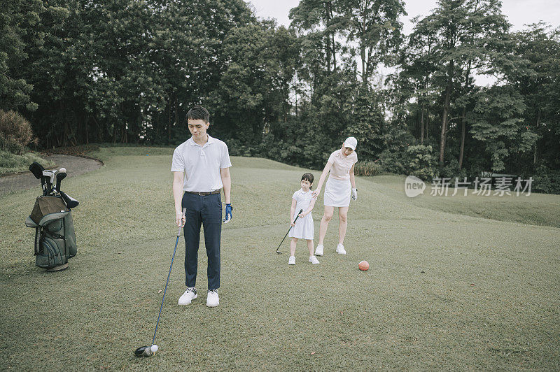 Asian chinese young couple golfer teeing off and swing his driver club on the golf course